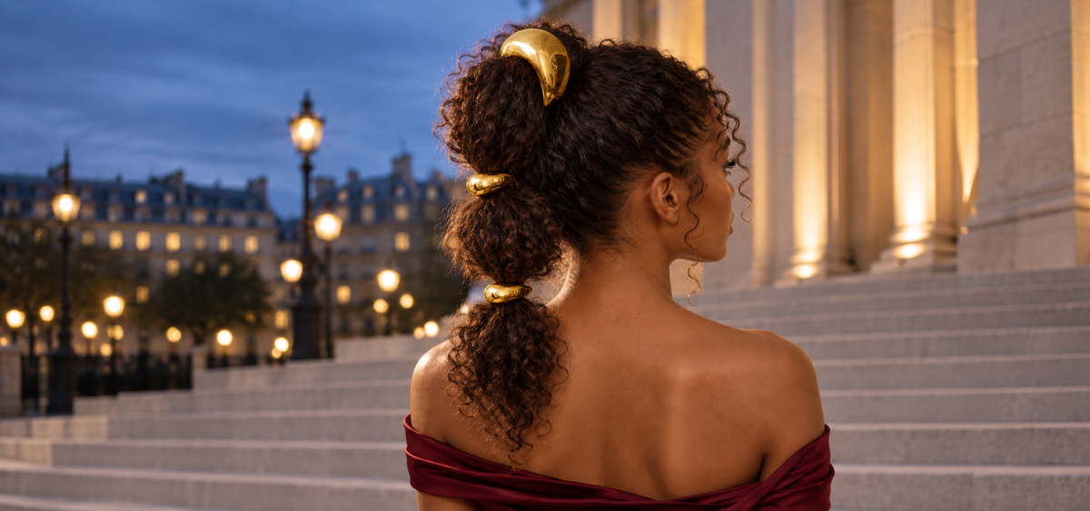 Nest Duo gold pony cuffs worn in curly hair at dusk, model centered for homepage